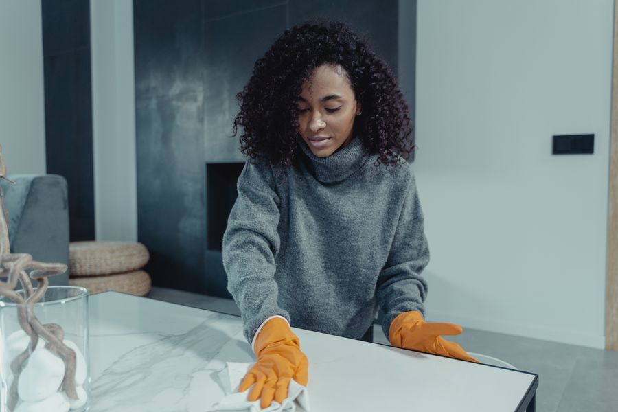 Cleaner in gloves wiping a table